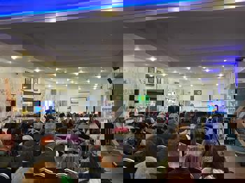 A room full of people sitting and watching a presentation